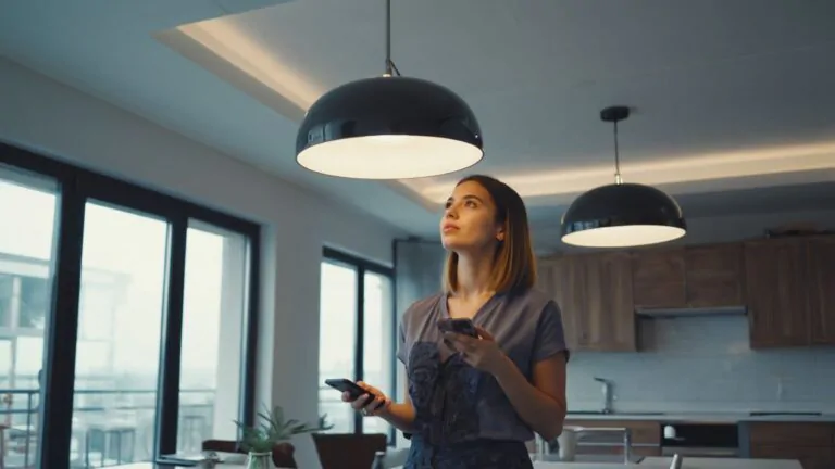 Žena na mobilu v aplikaci nastavuje chytrou žárovku Oranžovku