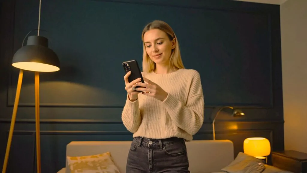 Žena na mobilu v aplikaci nastavuje noční režim světla