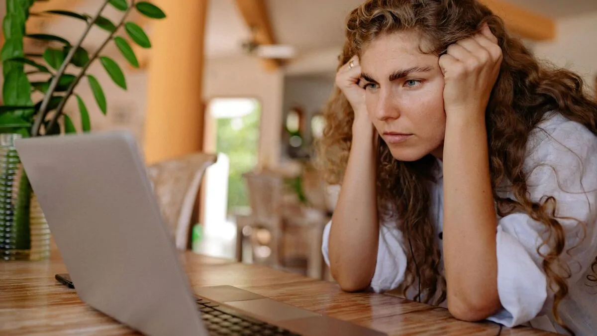 Žena se dívá do monitoru notebooku a mračí se