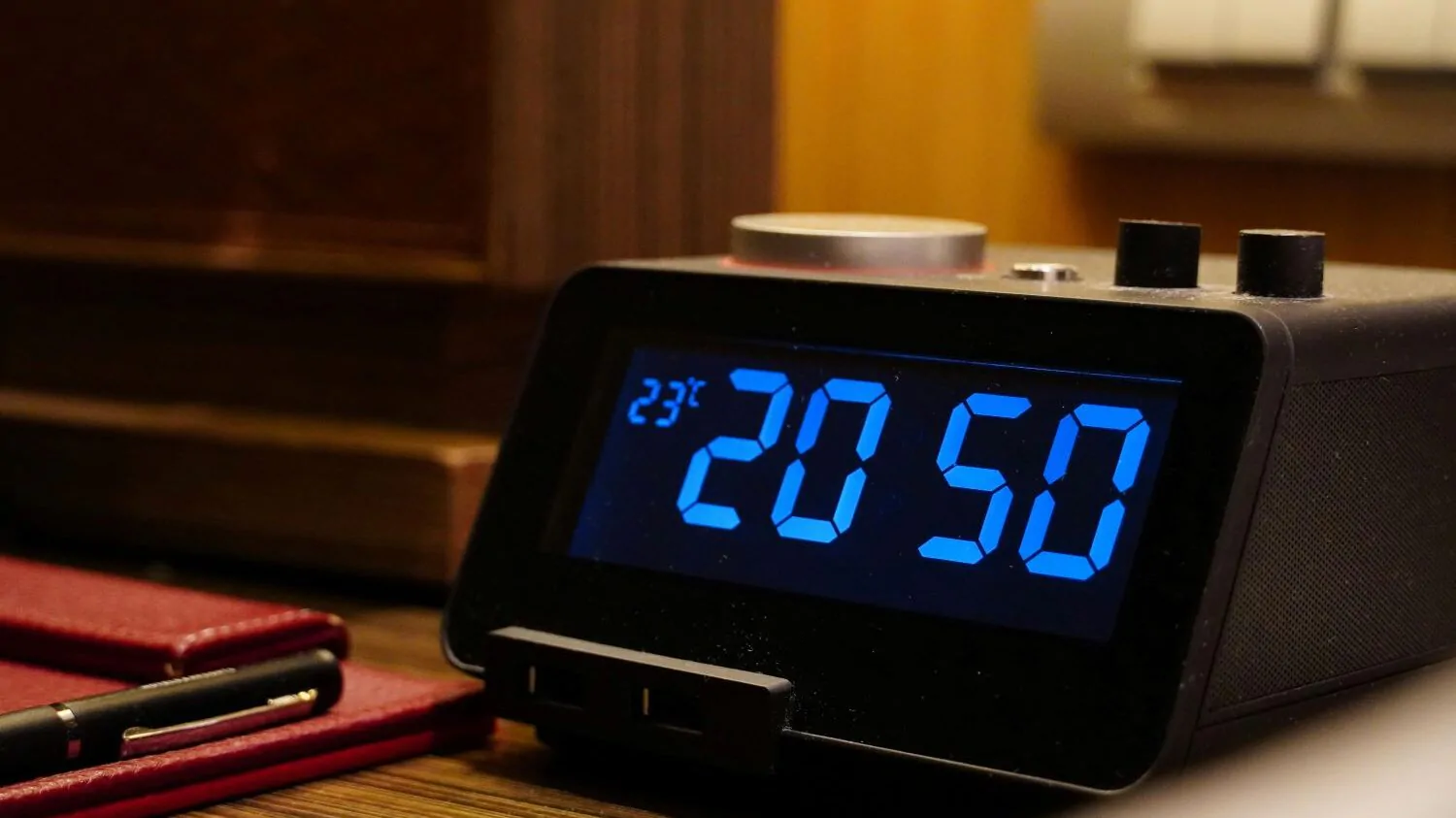 Budík u postele ukazuje čas 20:50