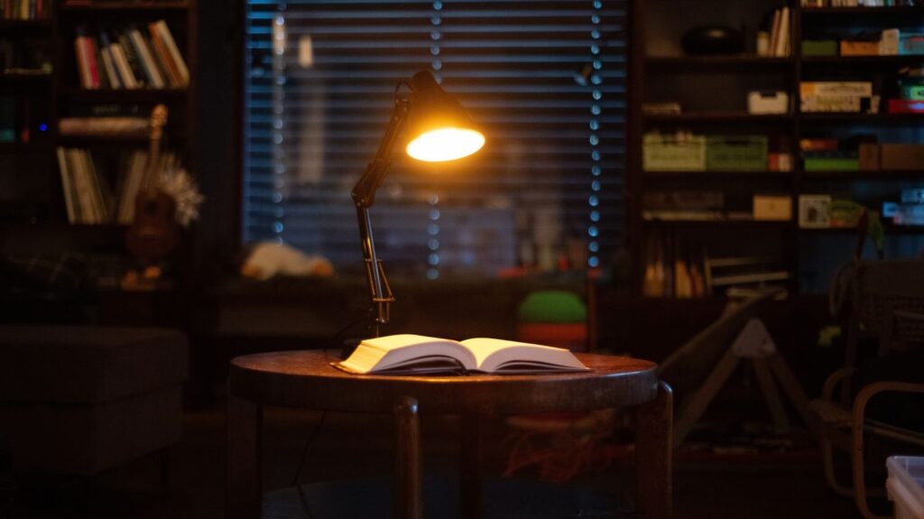 Večerní stolní lampa ORANŽOVKA bez modrého světla svítí na knihu na stole