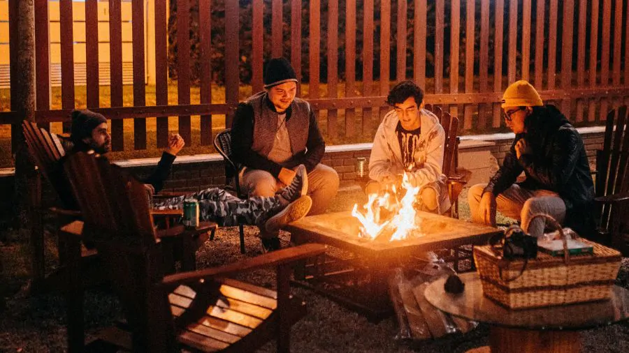 Přátelé večer sedí u ohně.