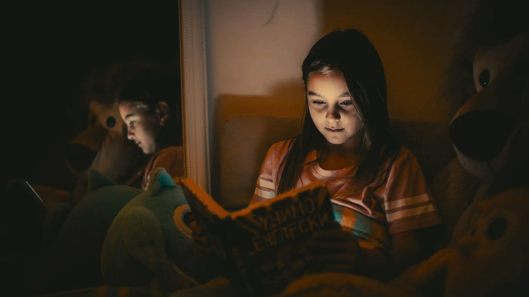 Dívka si večer čte v autě